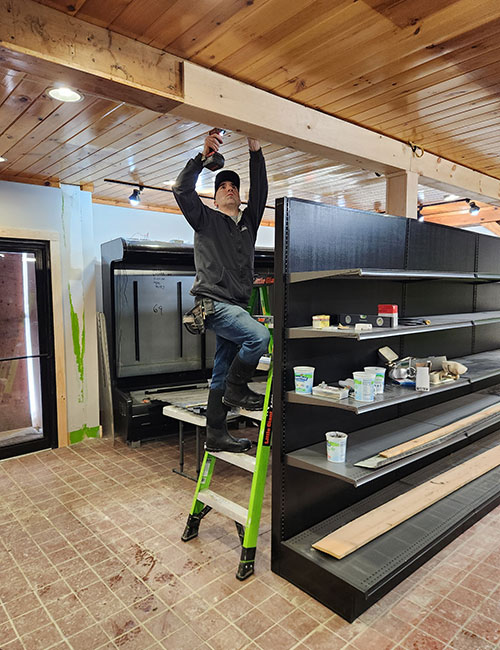 Photo: Mike Mignone makes renovations at the new general store in Johnson, which he owns with his wife, Haley Newman. Photo: Haley Newman.