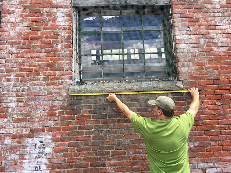 Photo: Artist Rich Gillis earmarks materials from mill in 2018 for kiosk creation. Photo by Maia Segura;