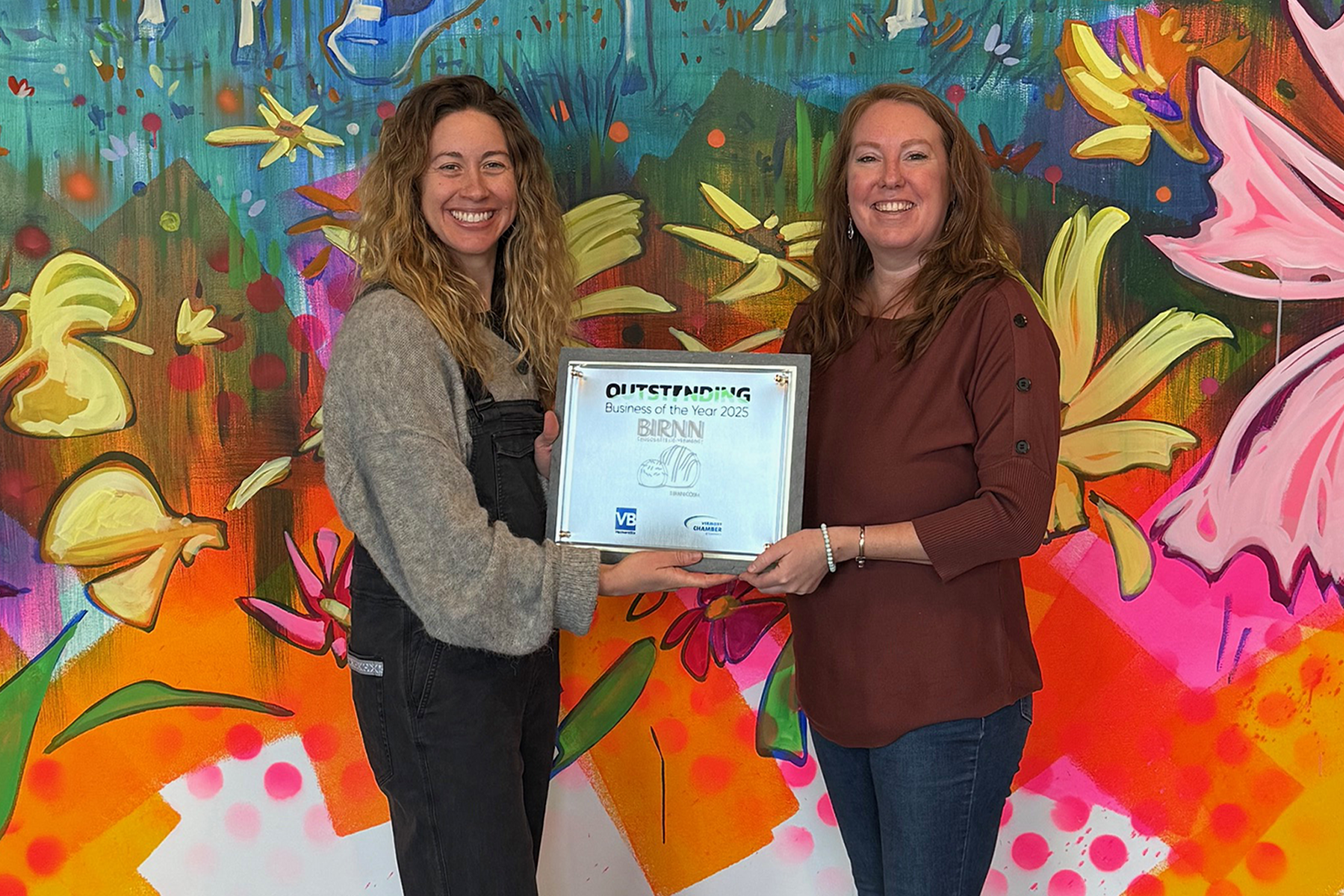 Photo: Katie Kittell, publisher of VermontBiz presents the 2025 Outstanding Business of the Year plaque to Julia Birnn Fields, president & owner of Birnn Chocolates of Vermont. VermontBiz photo.