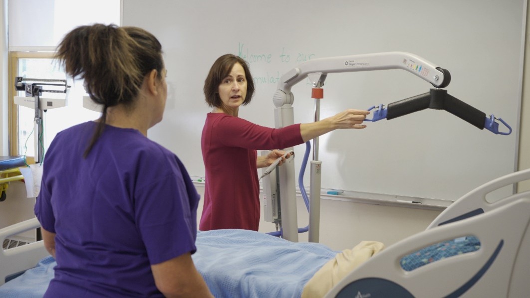 NVRH photo of Director of Nursing Education Britta Hensel demonstrates equipment for a student.