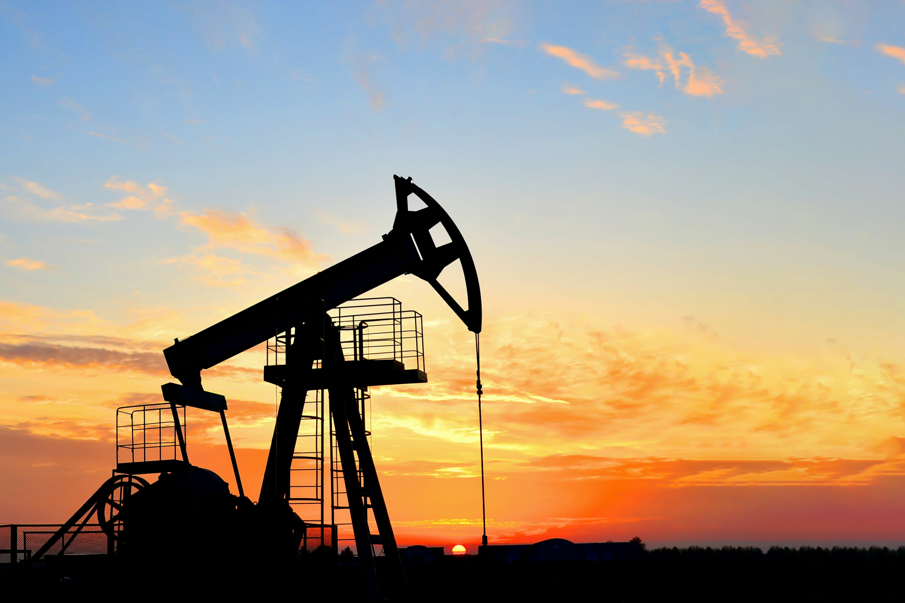 Oil-drilling derricks are shown at a desert oil field.&nbsp;