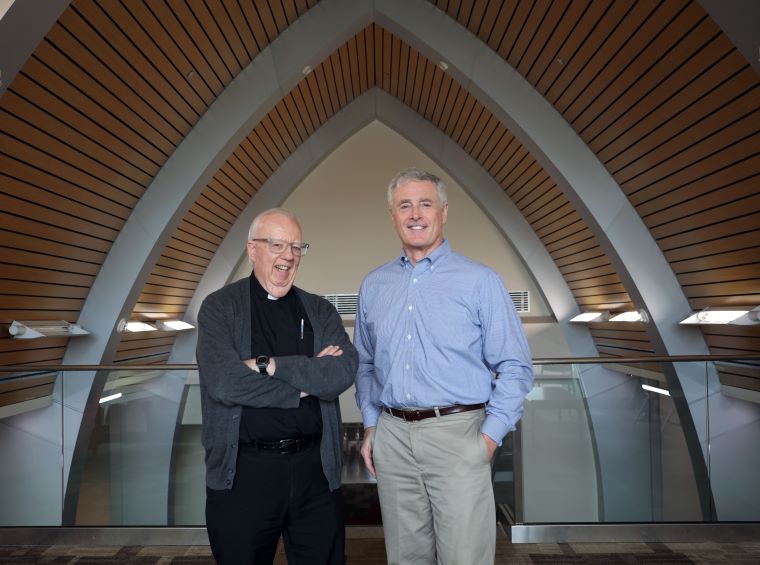 Fr. David Theroux S.S.E. ’70, left, and College President Richard Plumb, Ph.D.