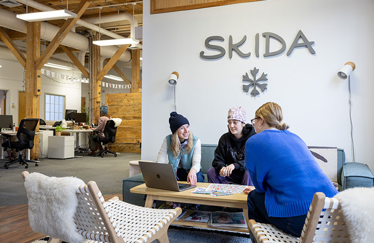 Photo: Prevot, left, meets with colleagues at Skida’s Burlington office. Photo: Baldwin Photography.
