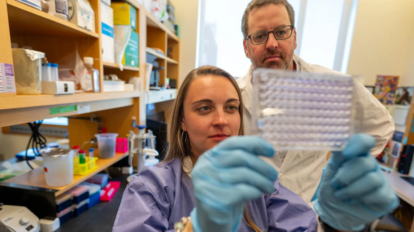 UVM scientists Victoria Gibson and Brian Cunniff working in a lab at the Cancer Center. 