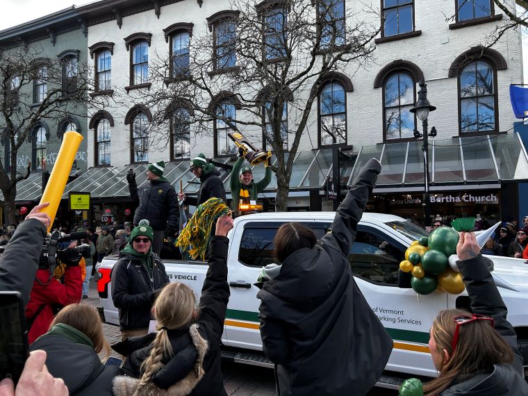 UVM Head Soccer Coach Rob Dow holds up the National Championship trophy during the Sunday parade up Church Street in Burlington. VermontBiz photo.