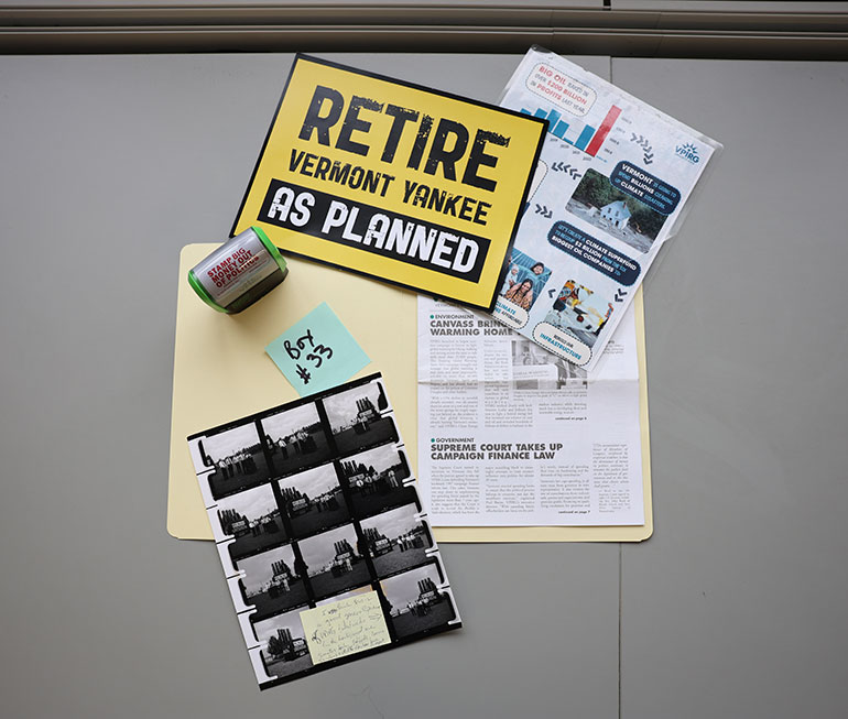Photo: Artifacts from collection box #33 – a photo contact sheet, posters, pamphlets, self-inking stamp that says “Stamp Big Money Out of Policitcs”-- all indicative of items in the collection and materials created by VPIRG over their decades of community engagement and activism. Courtesy photos.