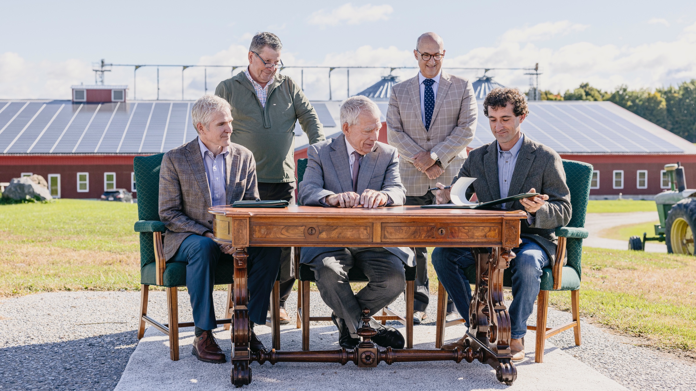 Nordic Farm property co-owner Benjamin Dobson and officials from UVM and the USDA's Agricultural Research Service sign a long-term lease agreement on the antique desk that belonged to Vermont Senator Justin Morrill—author of the Land-Grant College Act of 1862